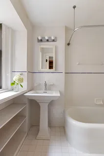 a bathroom with a sink a bathtub and a window