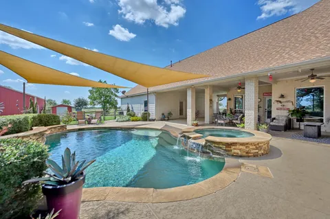 a view of a swimming pool with outdoor seating and a patio