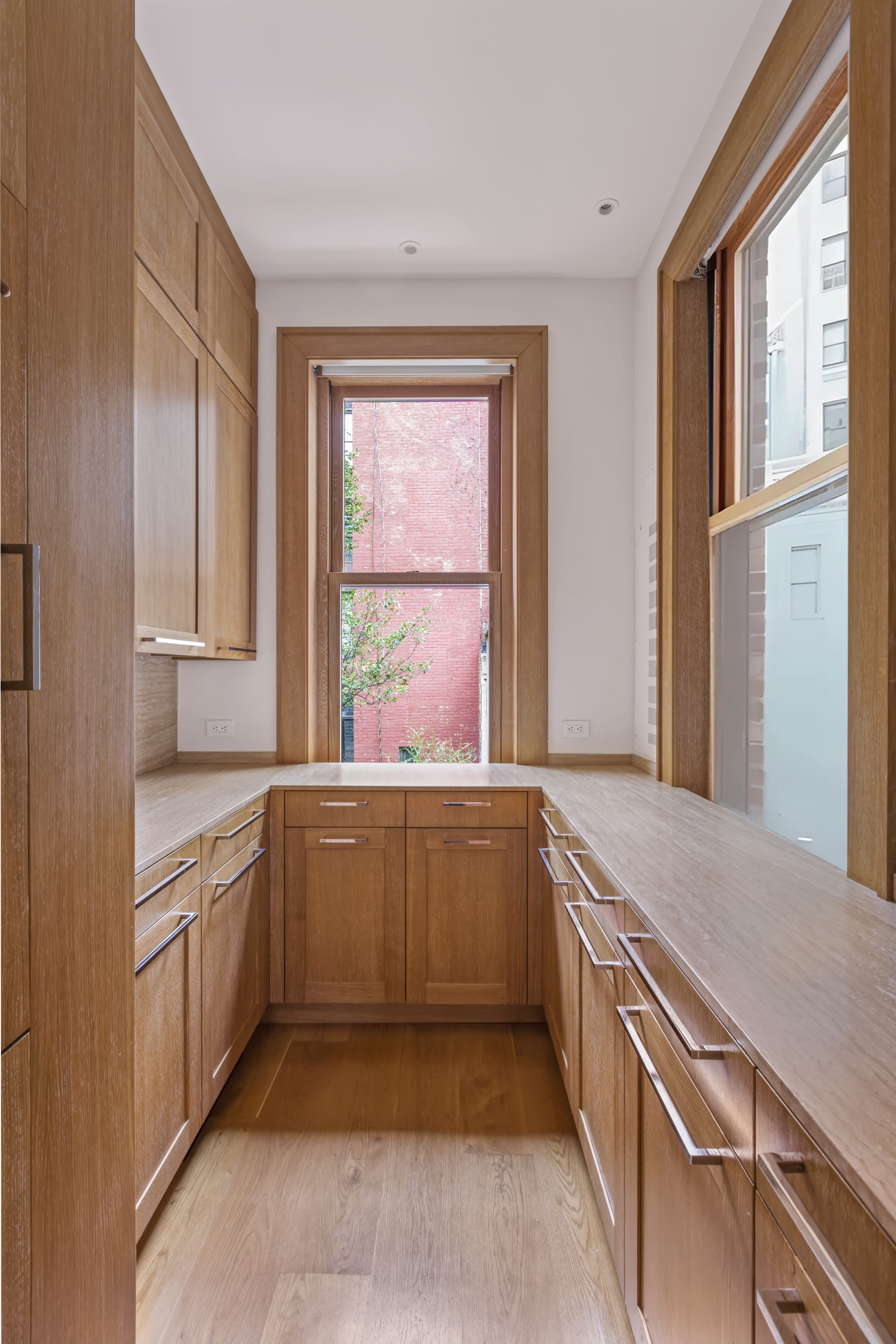 45 East 74th Street Manhattan, NY 10021 - Photo 12 of 33 a kitchen with granite countertop a sink and dishwasher with wooden cabinets