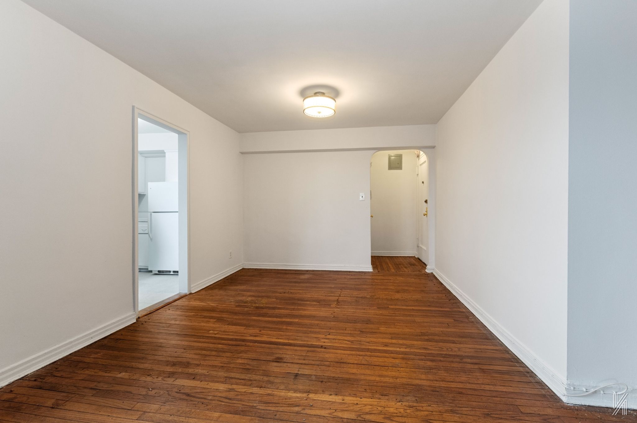 22-60 79th Street, Unit 3E Queens, NY 11370 - Photo 8 of 17 a view of an empty room with wooden floor and closet