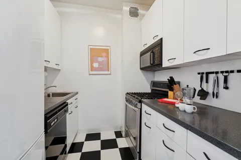 a kitchen with a sink a stove and cabinets