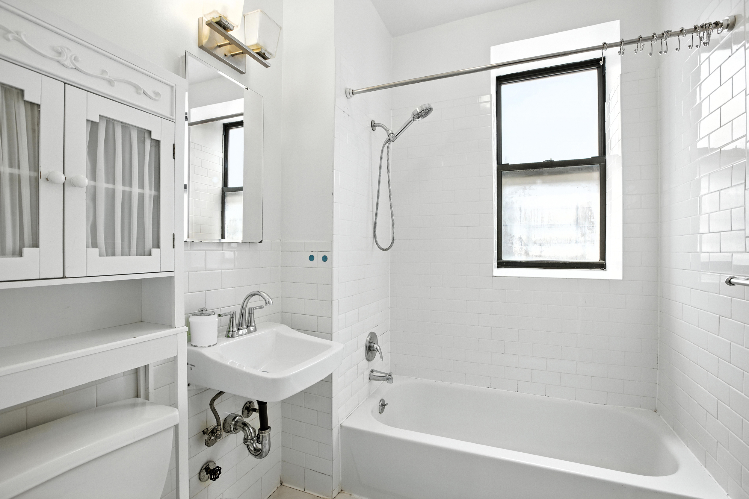 2611 Frederick Douglass Boulevard, Unit 4A Manhattan, NY 10030 - Photo 8 of 10 a white bath tub sitting next to a white sink and a shower