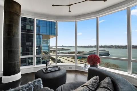 a view of a living room with furniture and floor to ceiling windows