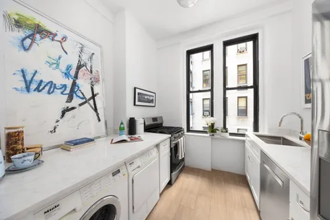 a view of a kitchen with a sink and wooden floor