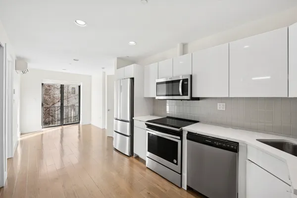 a kitchen with stainless steel appliances a stove a microwave and a hard wood floors