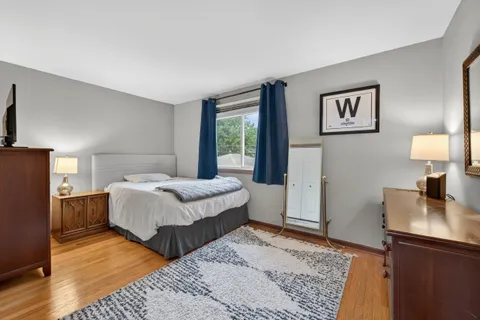a bedroom with a bed and a lamp on dresser