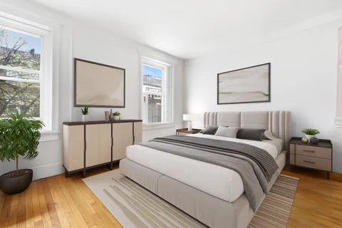 a bedroom with a bed and a potted plant