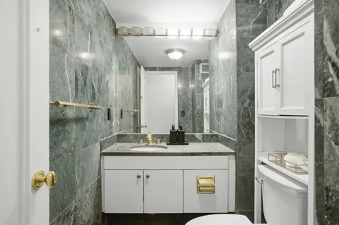 a bathroom with a granite countertop sink a mirror and a shower