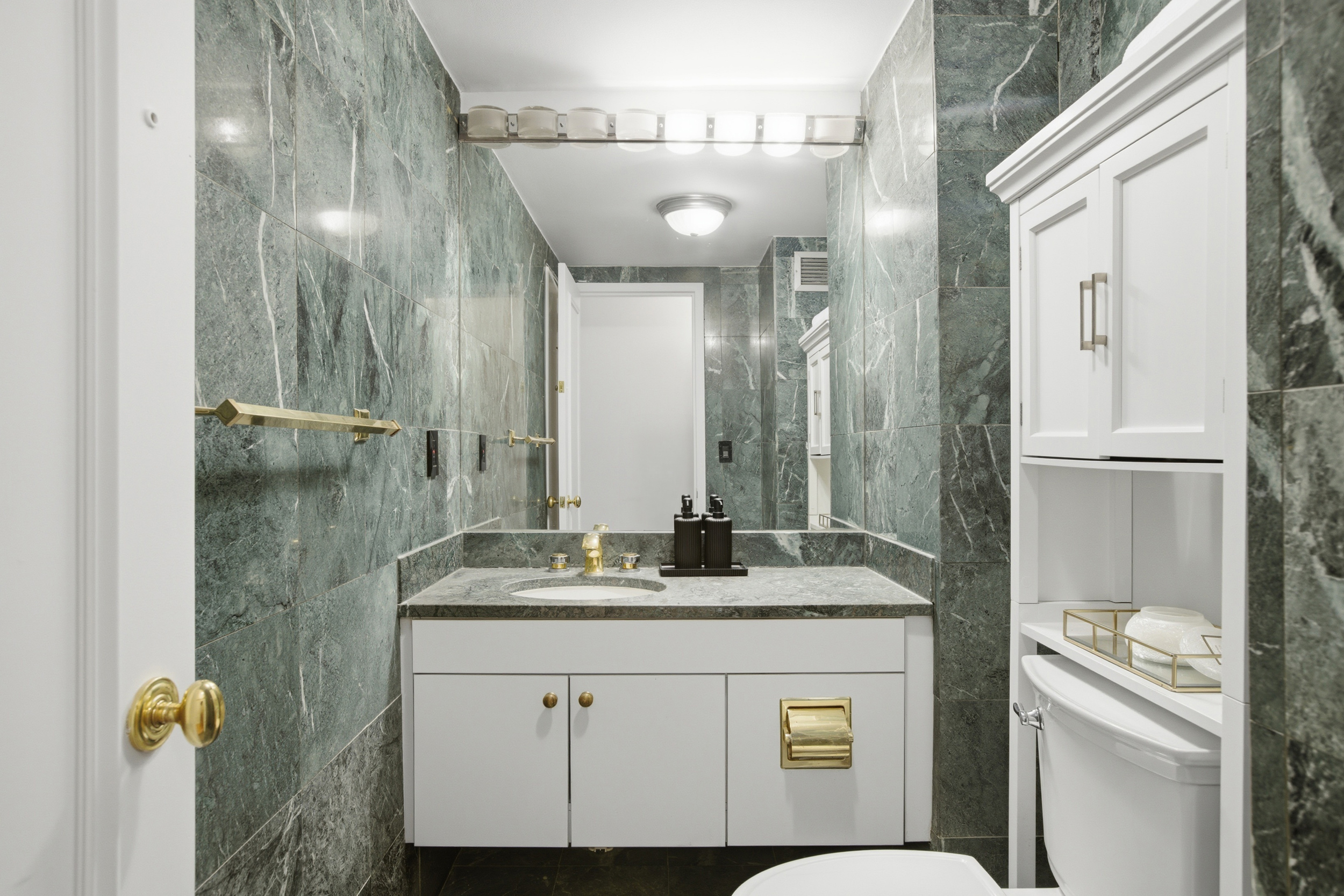 188 East 70th Street, Unit 3A Manhattan, NY 10021 - Photo 15 of 18 a bathroom with a granite countertop sink a mirror and a shower