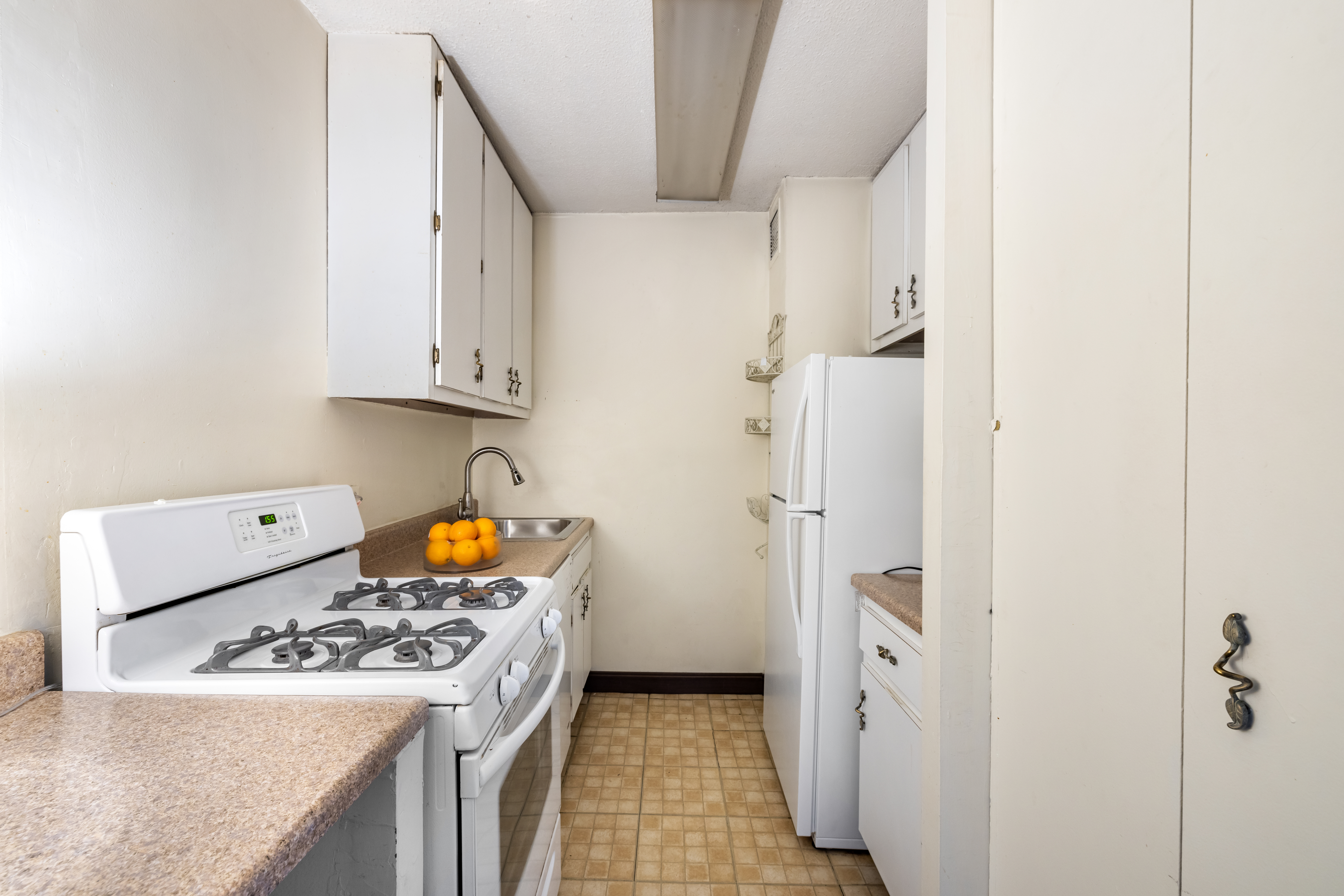 61 West 62nd Street, Unit 19C Manhattan, NY 10023 - Photo 4 of 7 a kitchen with stainless steel appliances granite countertop a sink stove and refrigerator