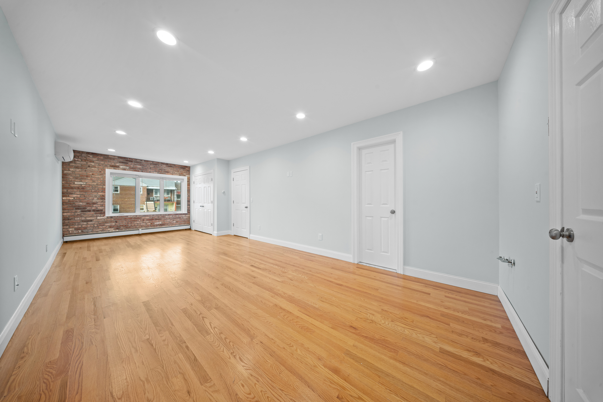52-19 69th Street Queens, NY 11378 - Photo 7 of 35 a view of an empty room with wooden floor and windows
