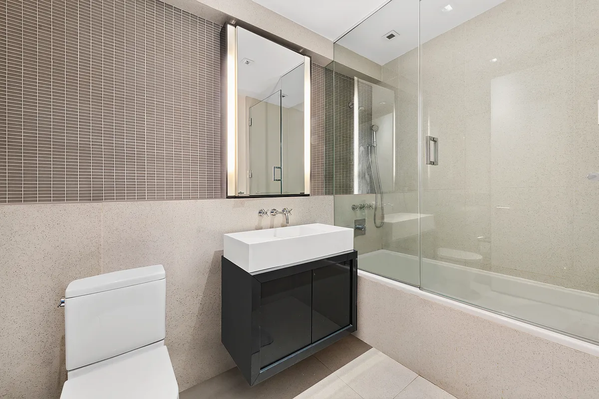 300 East 23rd Street, Unit 5B Manhattan, NY 10010 - Photo 8 of 10 a bathroom with a sink a toilet and shower
