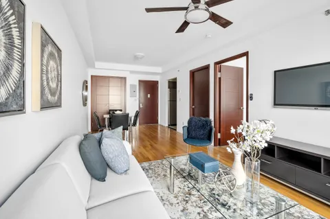 a bedroom with a bed potted plant on the dresser and a large window