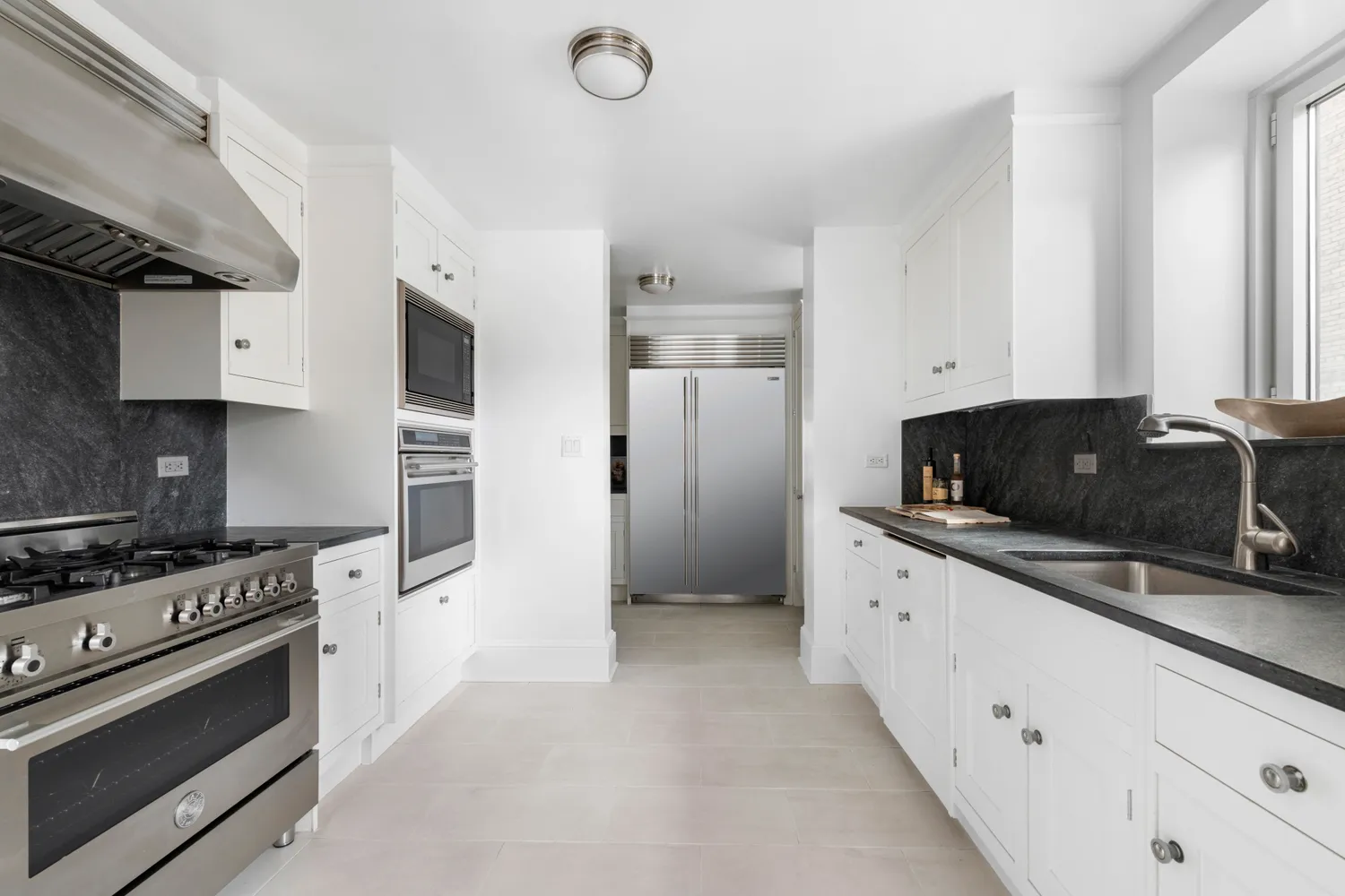 a kitchen with white cabinets and appliances