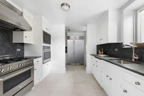 a kitchen with white cabinets and appliances