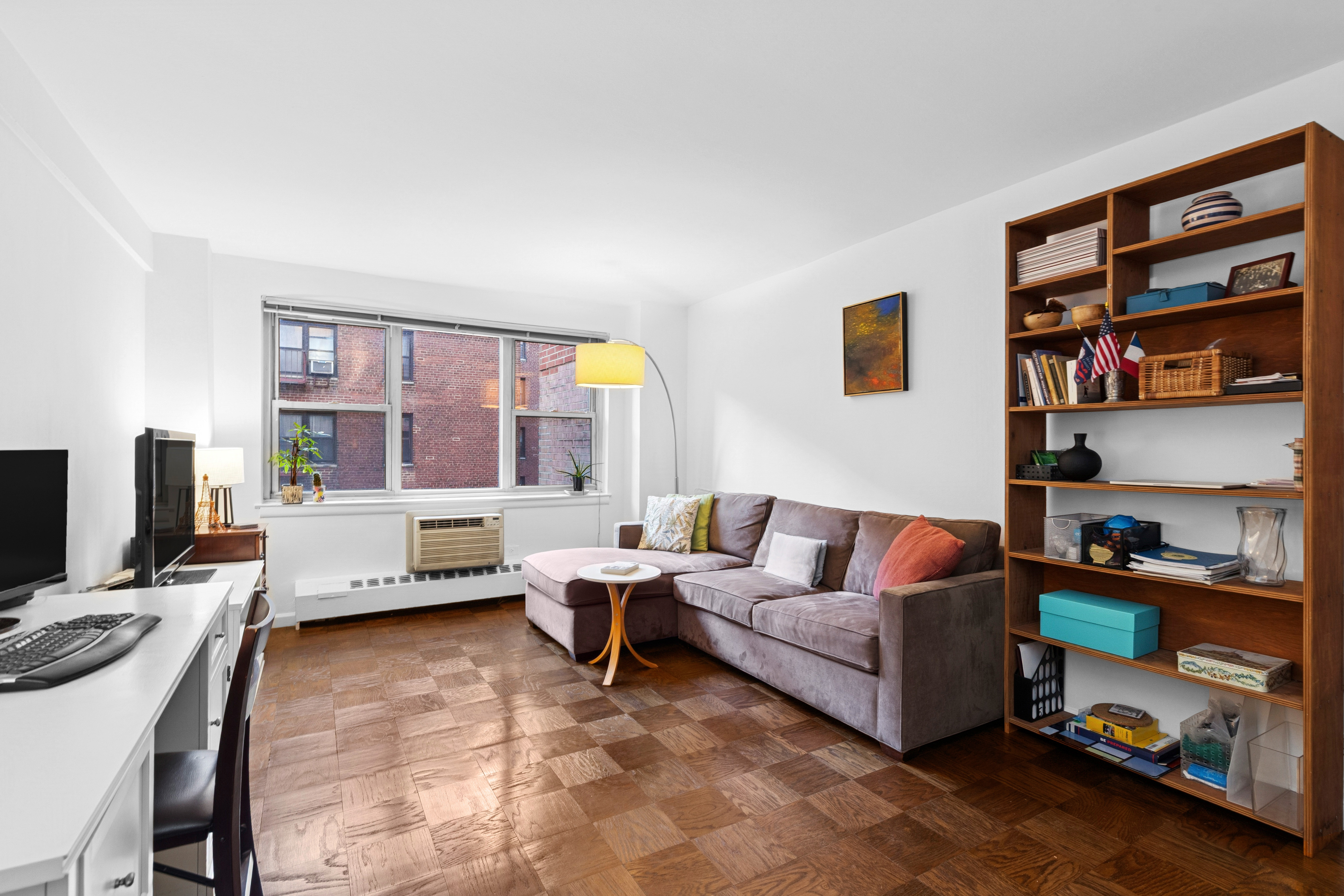 333 East 79th Street, Unit 5P Manhattan, NY 10075 - Photo 2 of 13 a living room with furniture a bookshelf and a window