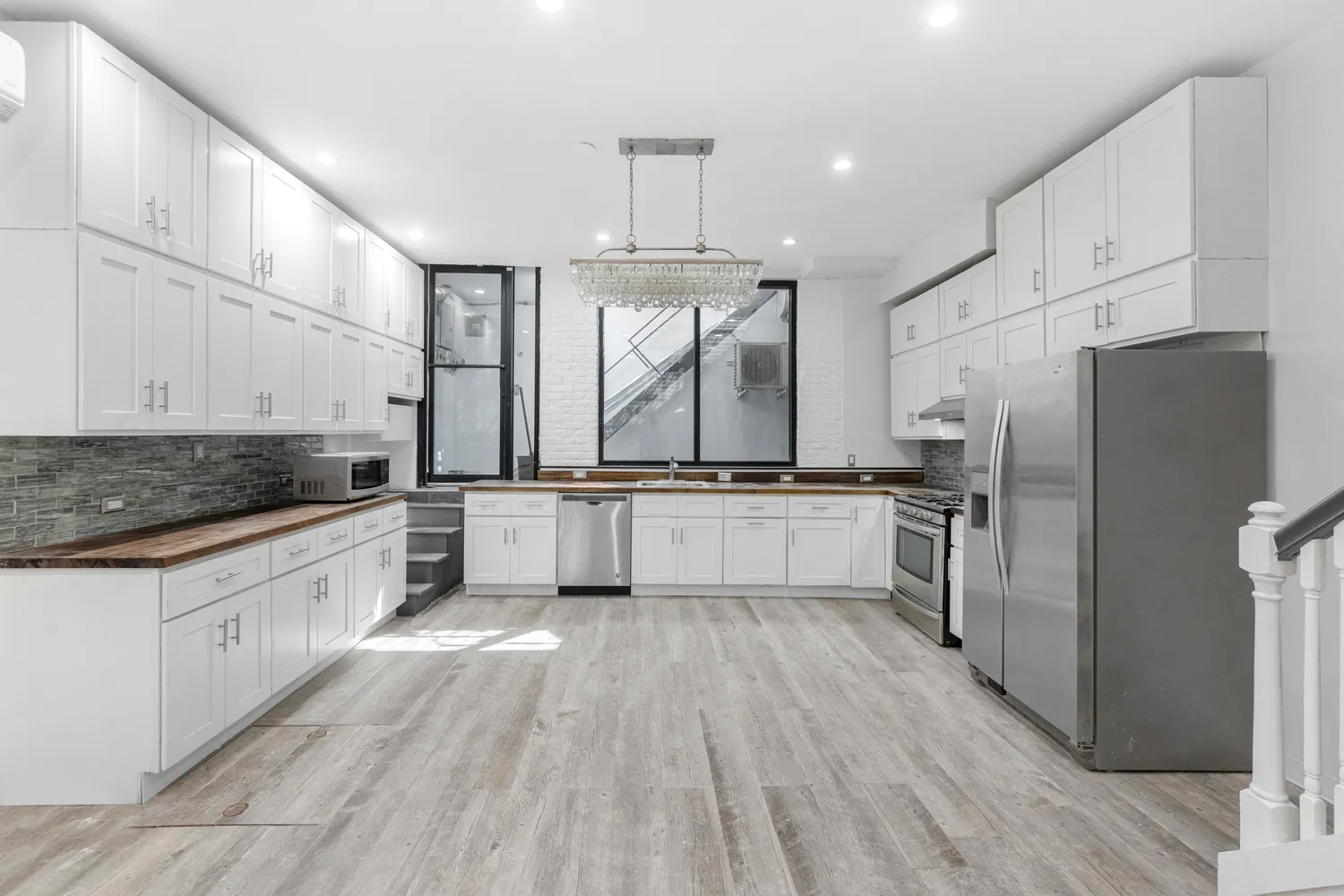 a large kitchen with cabinets wooden floor and stainless steel appliances