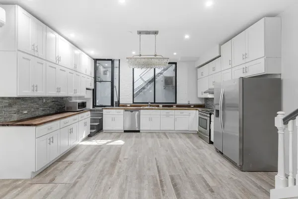 a large kitchen with cabinets wooden floor and stainless steel appliances