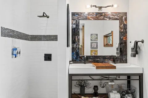 a bathroom with a granite countertop sink and a mirror