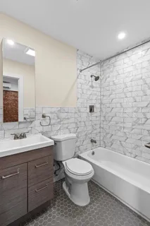 a bathroom with a double vanity sink toilet and shower