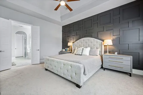 a bedroom with a bed and a ceiling fan