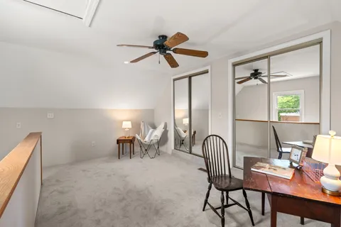a view of a workspace with furniture and a window