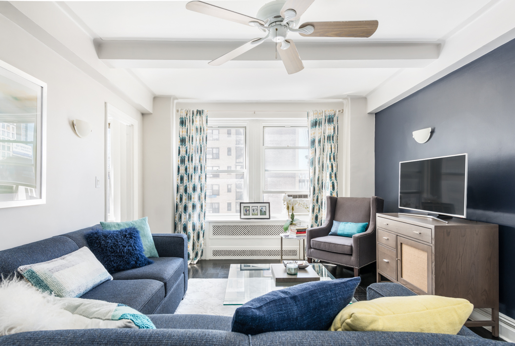 433 West 34th Street, Unit 7N Manhattan, NY 10001 - Photo 2 of 9 a living room with furniture and a flat screen tv