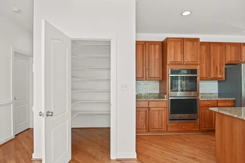 a kitchen with granite countertop stove top oven and cabinets