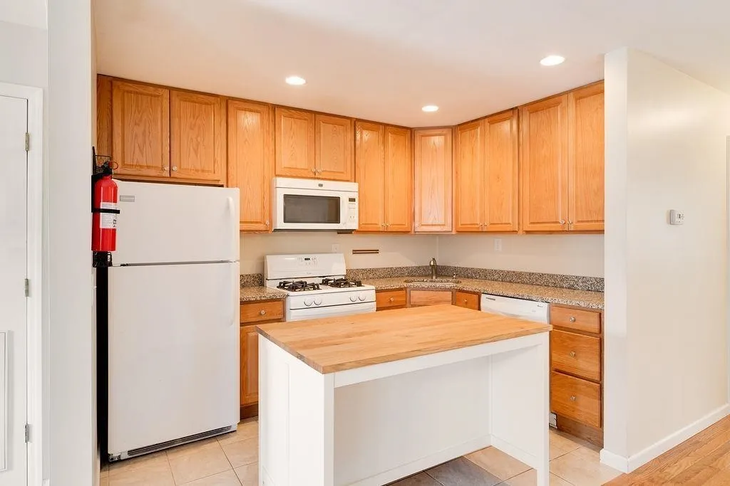 a kitchen with a refrigerator a stove top oven a sink and cabinets