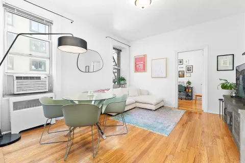 a living room with furniture a wooden floor and white walls