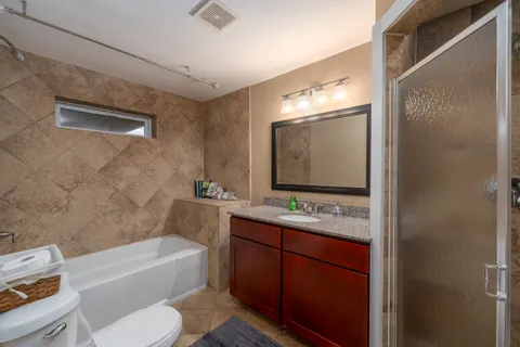 a bathroom with a sink vanity mirror bathtub shower and toilet
