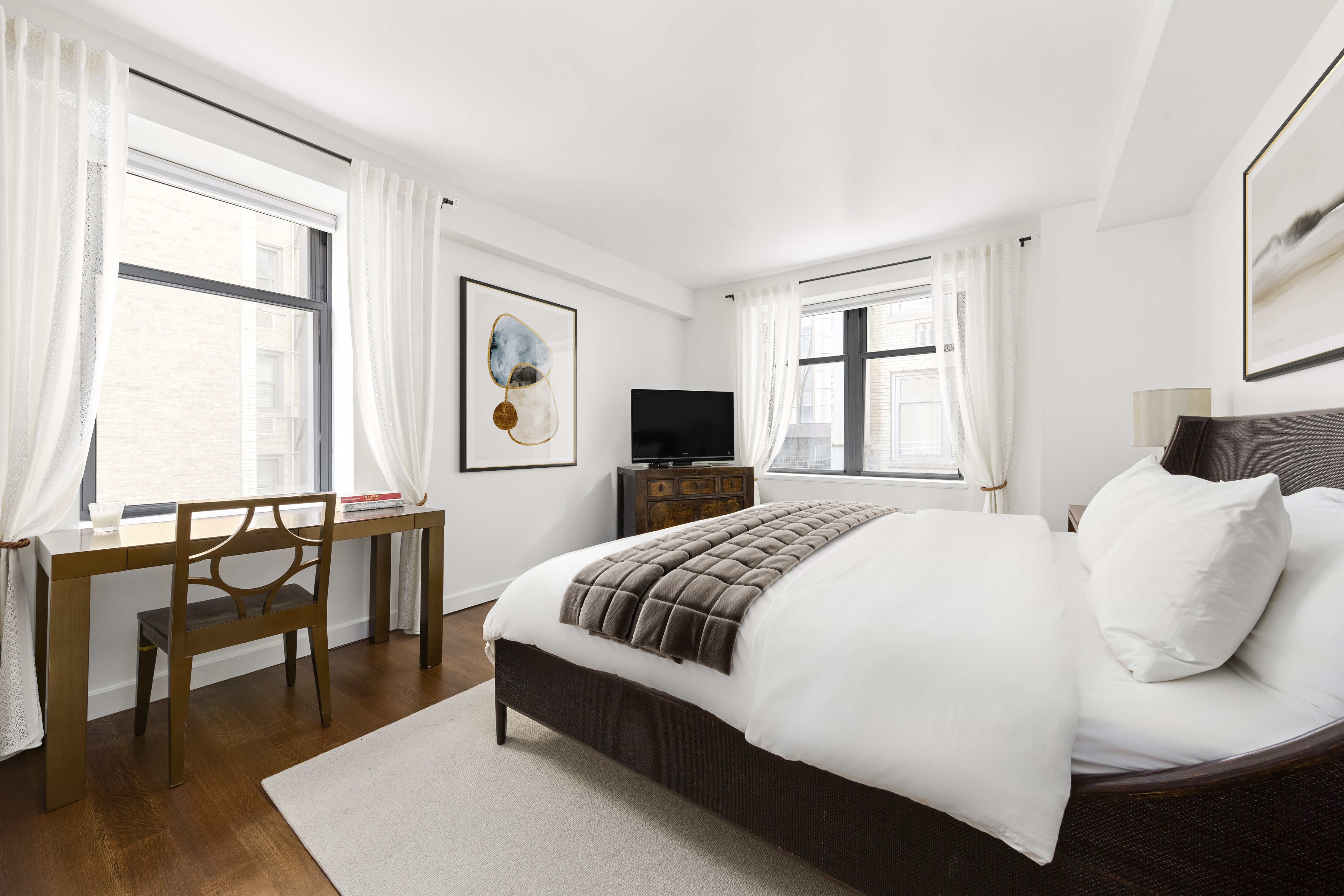 100 West 58th Street, Unit 9B Manhattan, NY 10019 - Photo 4 of 8 a bedroom with a bed and large windows