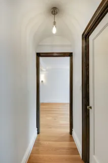 a view of a hallway with wooden floor and a hallway