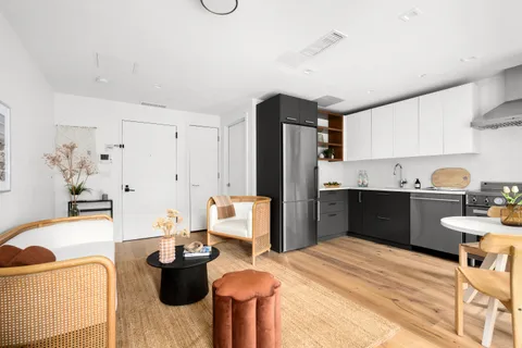 a kitchen with stainless steel appliances kitchen island granite countertop a refrigerator and a sink