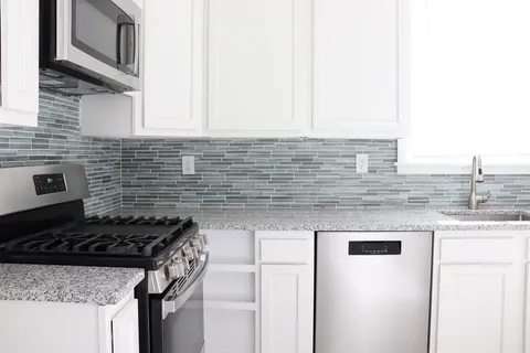 a kitchen with stainless steel appliances granite countertop a sink stove and cabinets