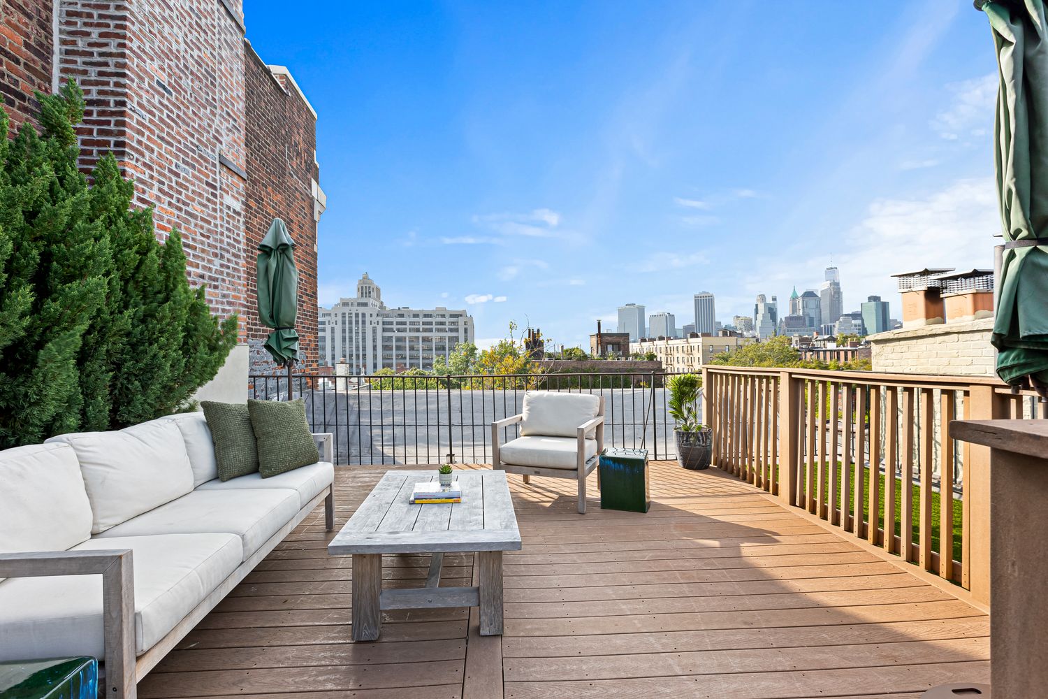 a roof deck with couches and wooden floor