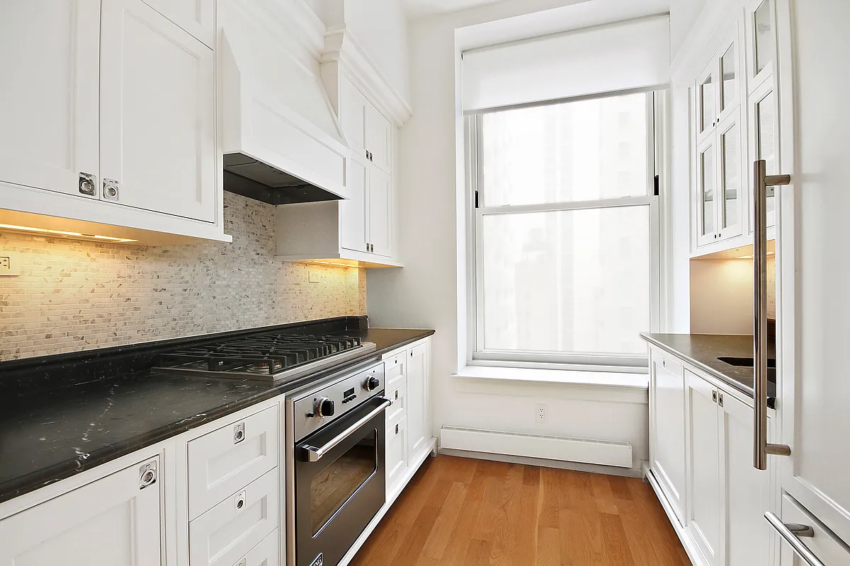 1 Central Park South, Unit 1010 Manhattan, NY 10019 - Photo 6 of 11 a kitchen with stainless steel appliances a stove a sink and a refrigerator