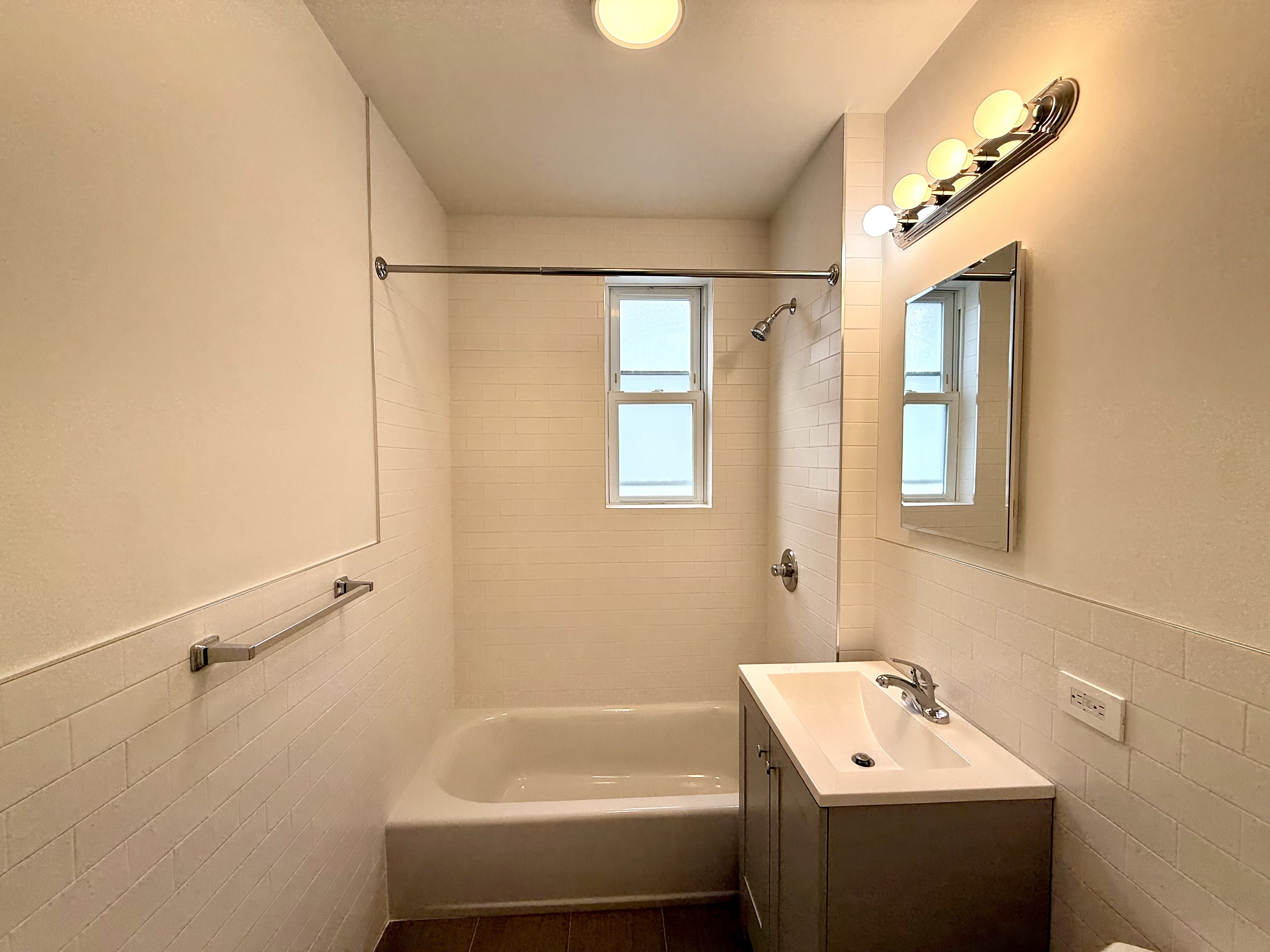 1675 85th Street, Unit 2R Brooklyn, NY 11214 - Photo 4 of 6 a bathroom with a tub sink and mirror