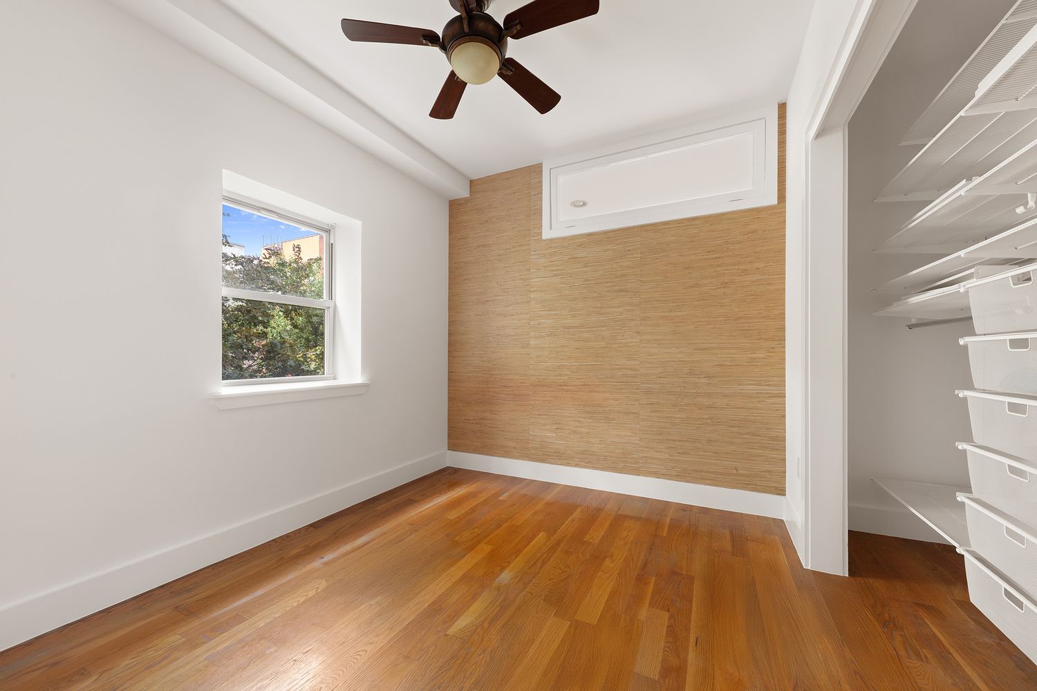 221 West 148th Street, Unit 4B Manhattan, NY 10039 - Photo 7 of 10 a view of an empty room with wooden floor and a window