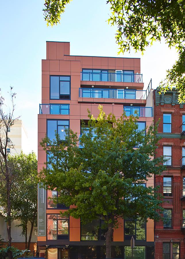 306 West 116th Street, Unit 1B Manhattan, NY 10026 - Photo 11 of 14 a front view of a building with a garden and plants