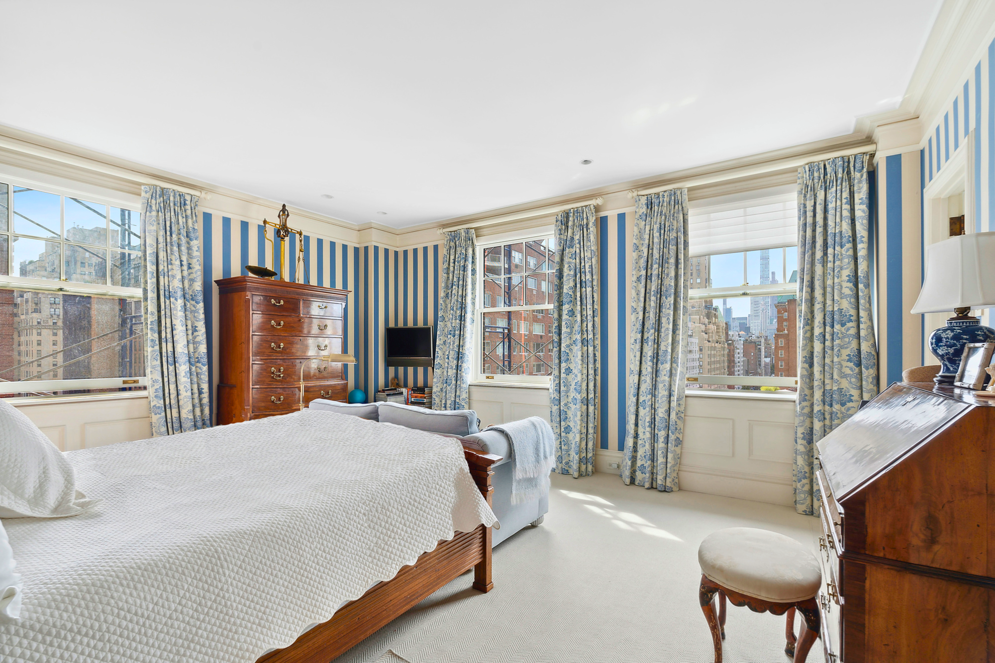 31 East 79th Street, Unit 10E Manhattan, NY 10075 - Photo 8 of 11 a bedroom with a bed wooden floor and a large window