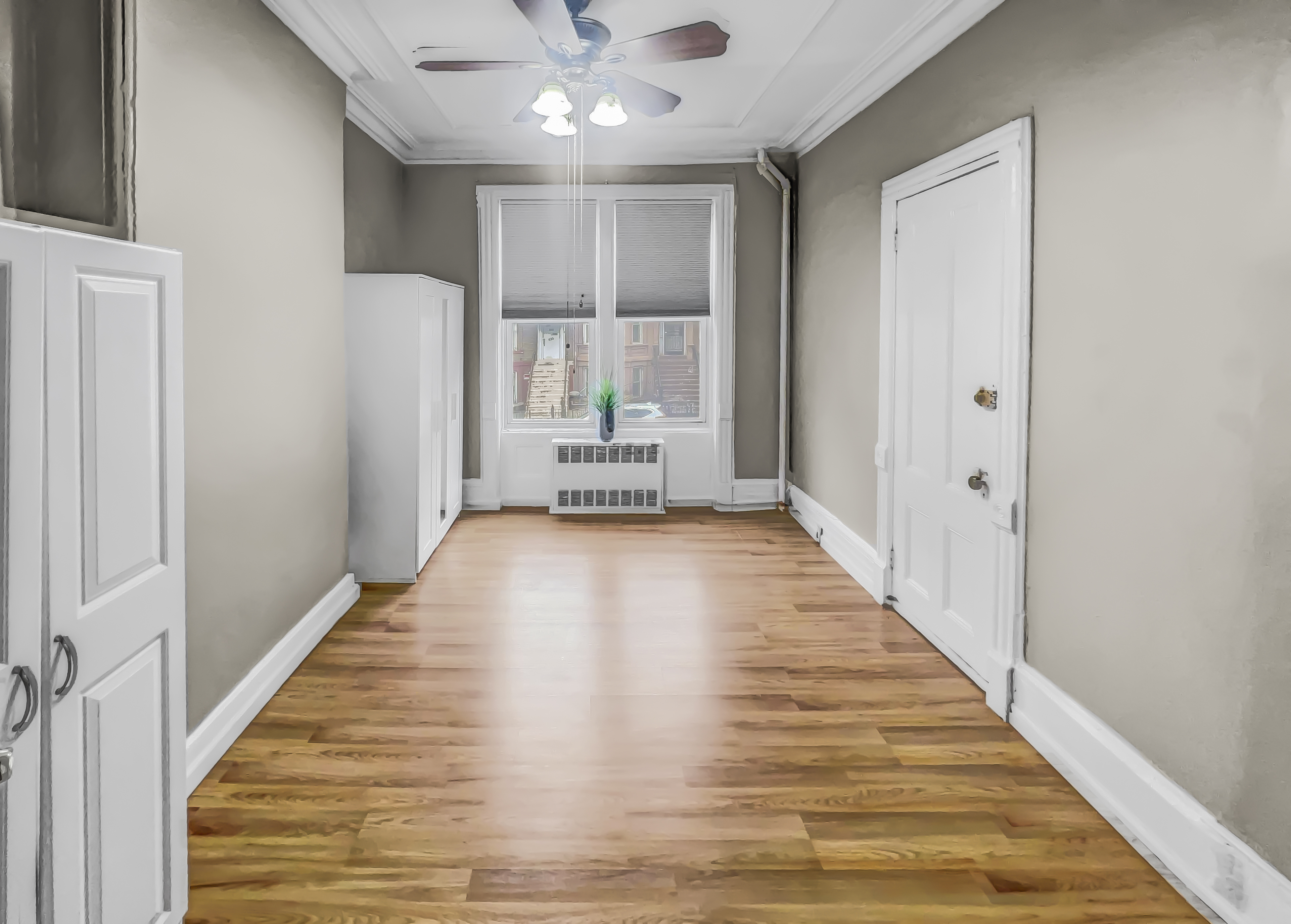 a view of a hallway with wooden floor and staircase