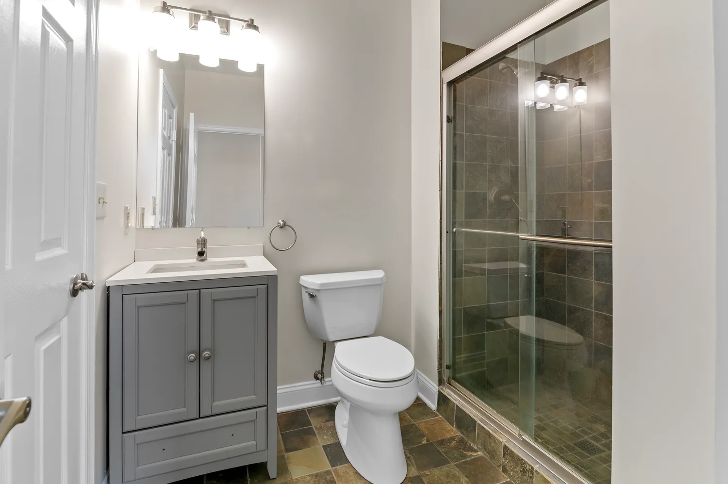a bathroom with a toilet a sink and glass door