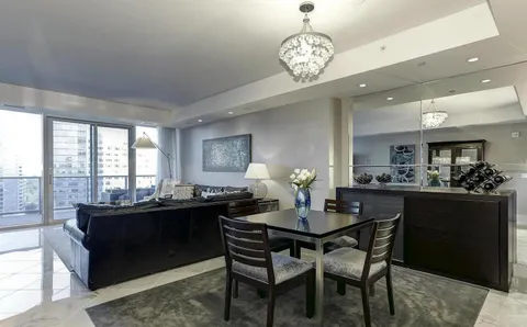 a dining room with wooden floor and chandelier