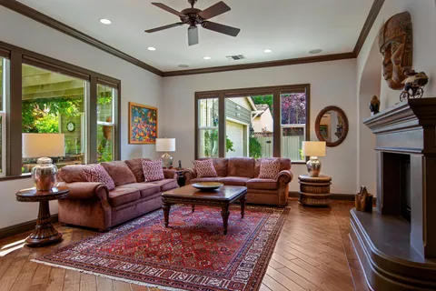 a living room with fireplace furniture and a large window