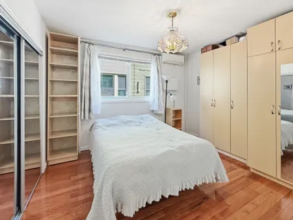 a spacious bedroom with a bed and a chandelier