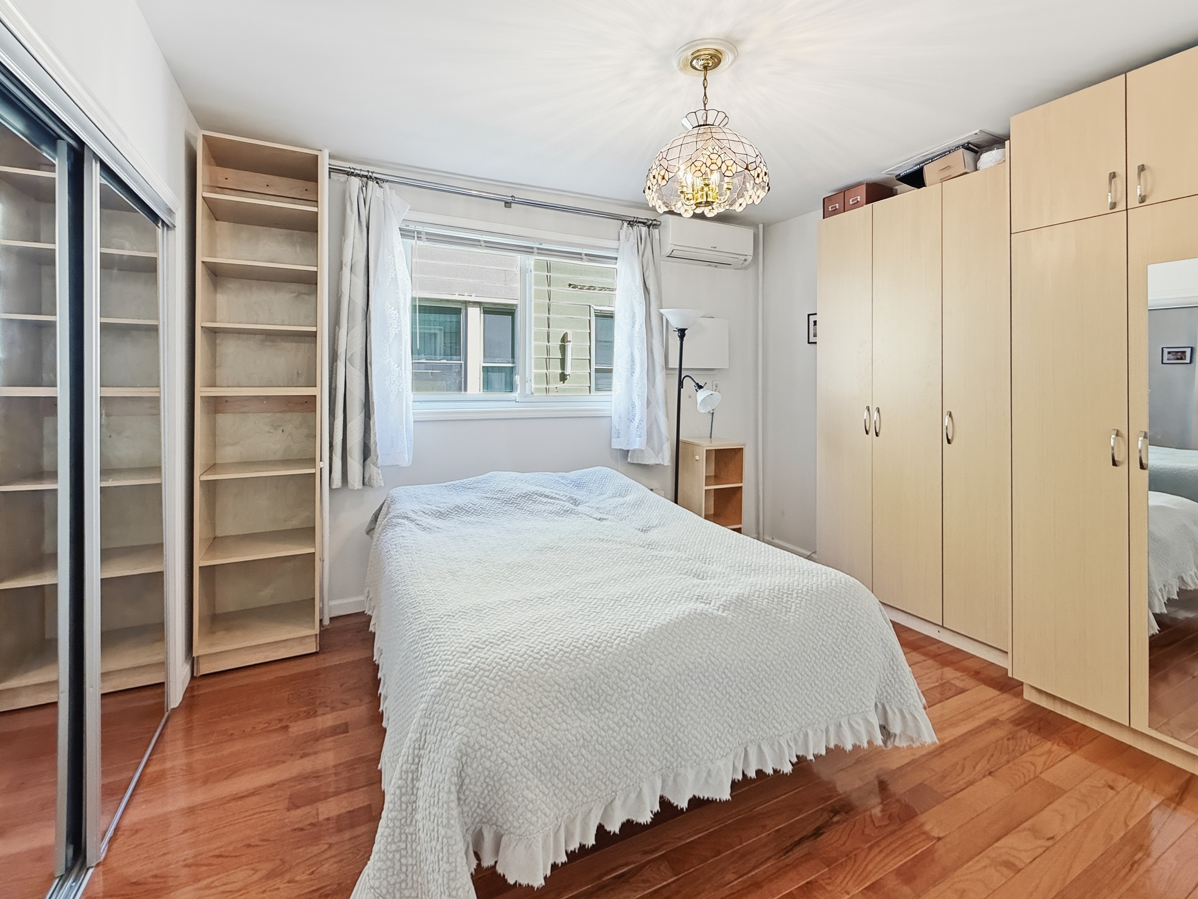 3735 Oceanic Avenue Brooklyn, NY 11224 - Photo 6 of 26 a spacious bedroom with a bed and a chandelier