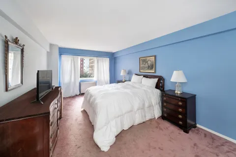 a bedroom with a bed flat screen tv and a window