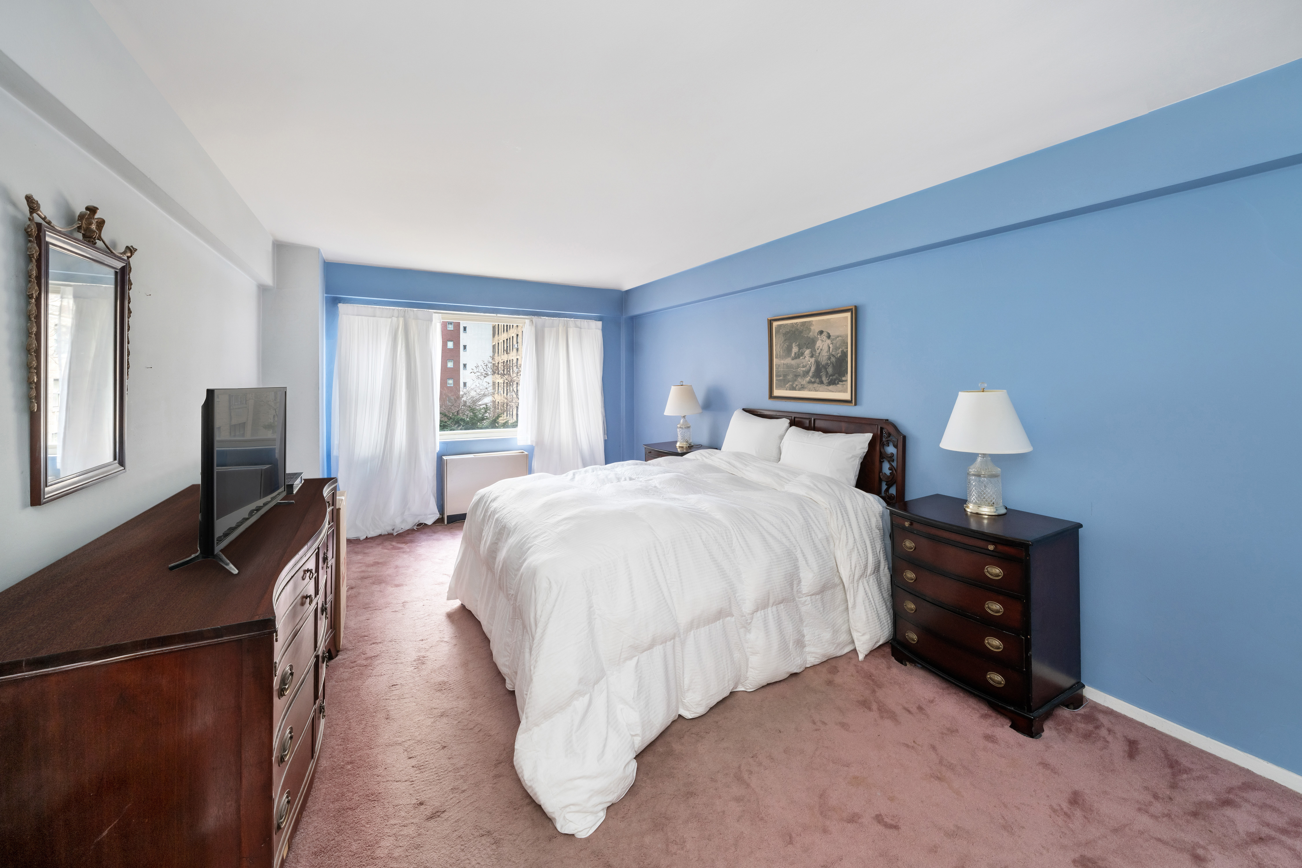 345 East 56th Street, Unit 5C Manhattan, NY 10022 - Photo 5 of 10 a bedroom with a bed flat screen tv and a window