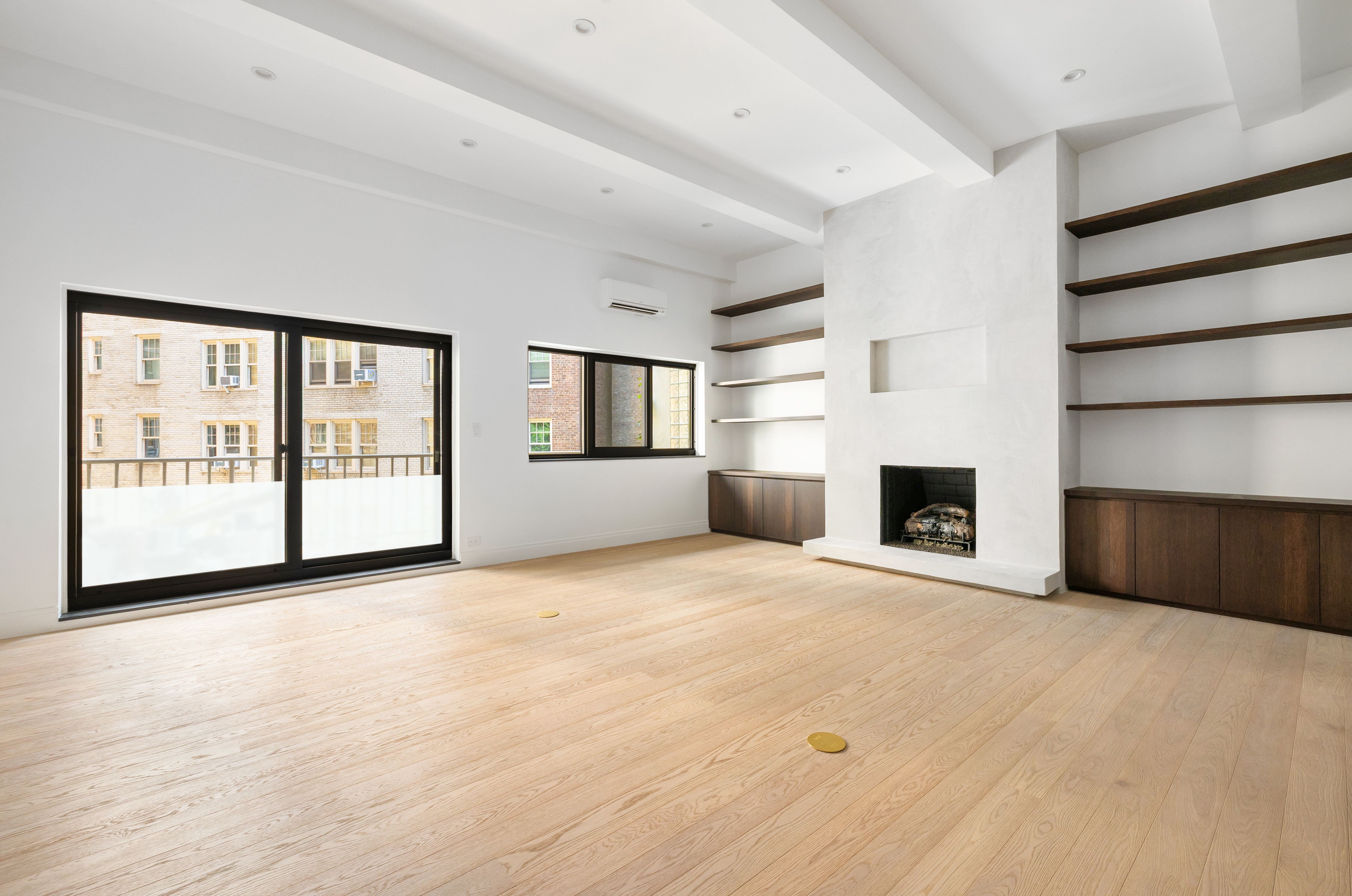 69 Bank Street, Unit 203 Manhattan, NY 10014 - Photo 3 of 23 a view of an empty room with a fireplace and a window